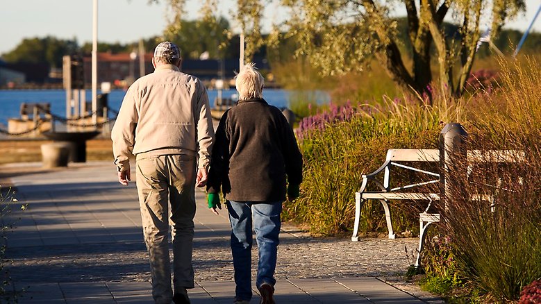 Ett äldre par promenerar vid kusten