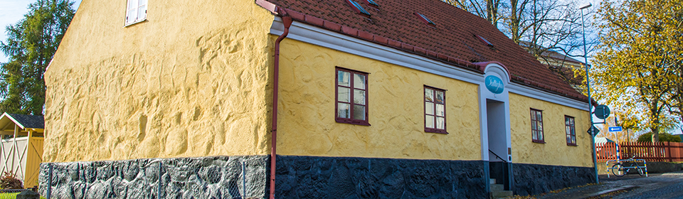 Ett gult vackert gammalt stenhus längs kullerstensgatan i Sölvesborgs stadskärna