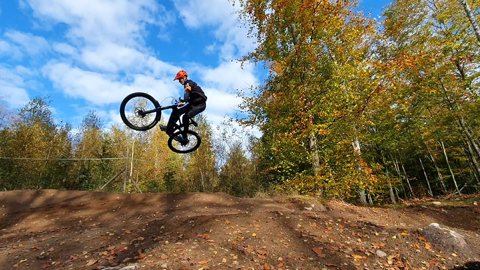 En cyklist gör ett högt hopp i luften med sin MTB cykel, i Ryssbergsskogen.
