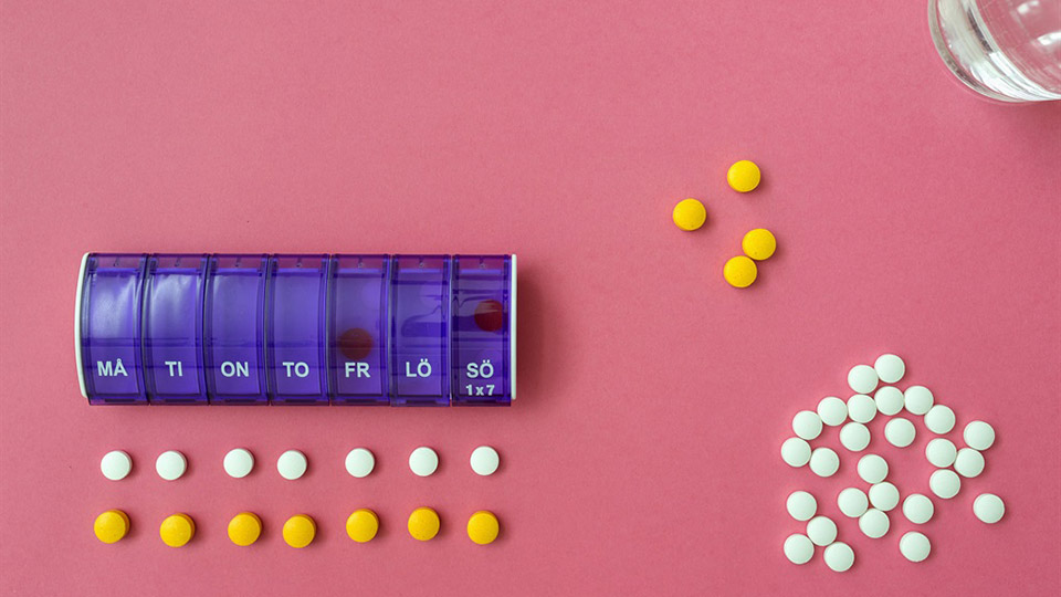 Tabletter och en dosett som ligger på ett bord
