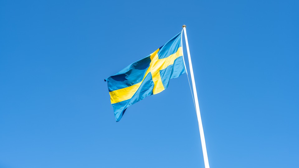 Svenska flaggan vajar i vinden en solig sommardag