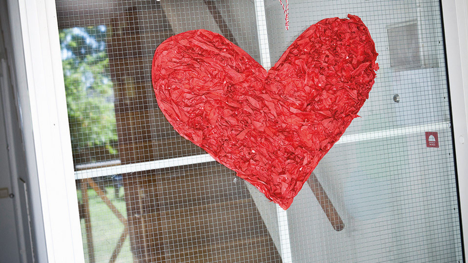 Bild på ett rött pappershjärta som hänger i fönster