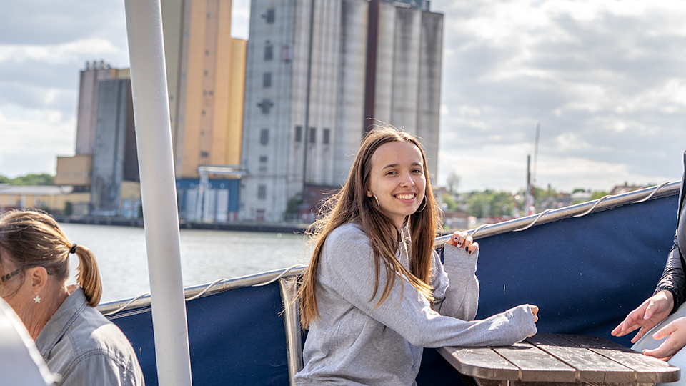 Ung tjej i åldern 17-18 år sitter på Glassbåten i Sölvesborgs innerhamn.