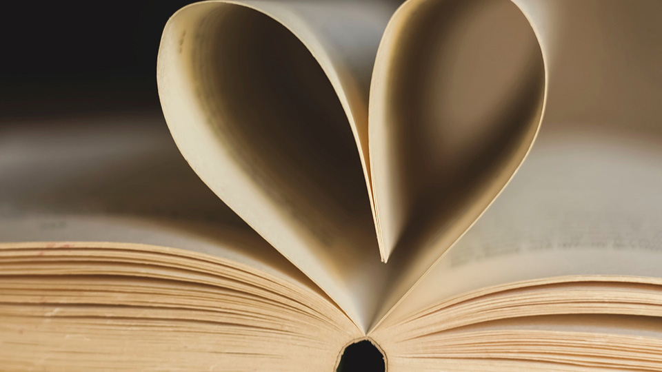 Två blad i en bok viks ihop och bildar ett hjärta