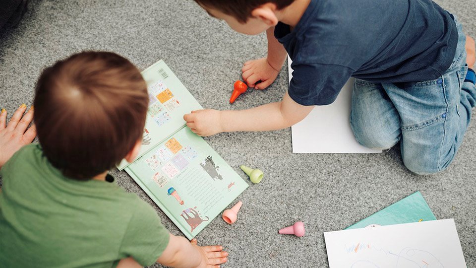 Barn leker och läser en bok foto: Scandinav bildbyrå