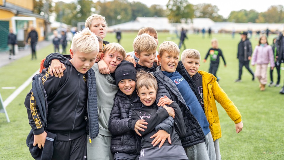 Elever från Havelidens skola i Hällevik håller om varandra på en fotbollsplan.