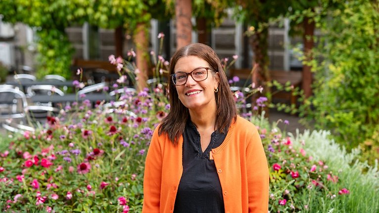Ella står framför blomsterrabatt vid stadshuset