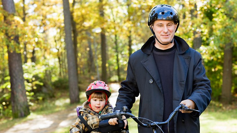Barn och vuxen med cykelhjälm.