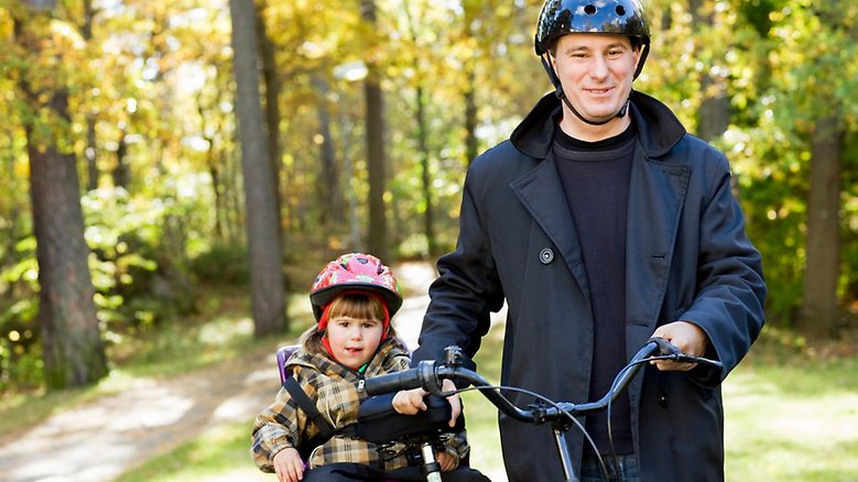 En pappa och hans dotter cyklar tillsammans. Foto.