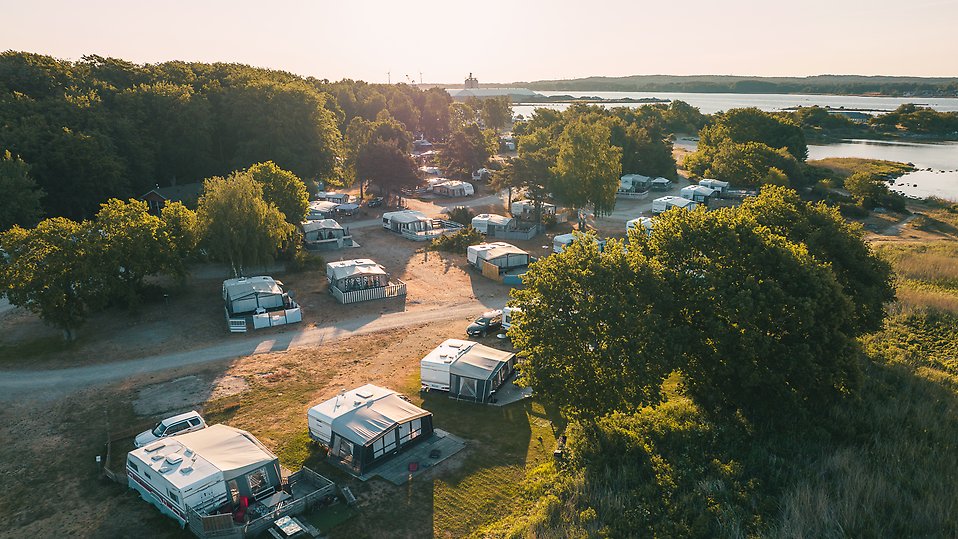 Drönarfoto över campingen med husvagnar och havet i bild.