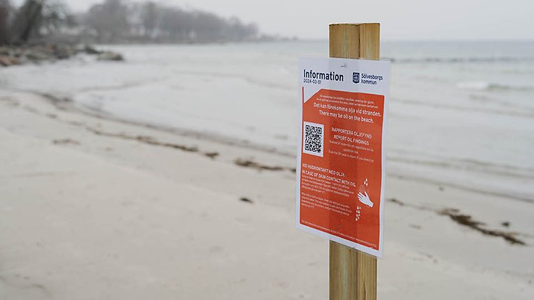 Informationsskylt på strand där lättnader av vistelseförbudet är